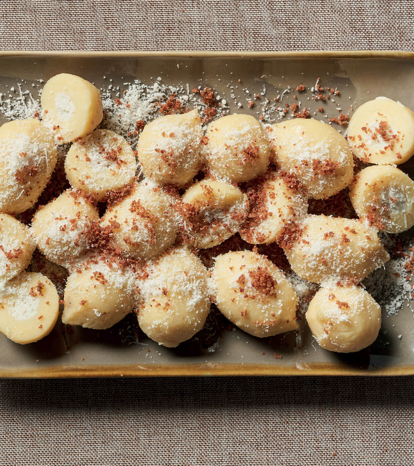 Potato gnocchi stuffed with PDO Gorgonzola with cream and speck powder -  mamma emma