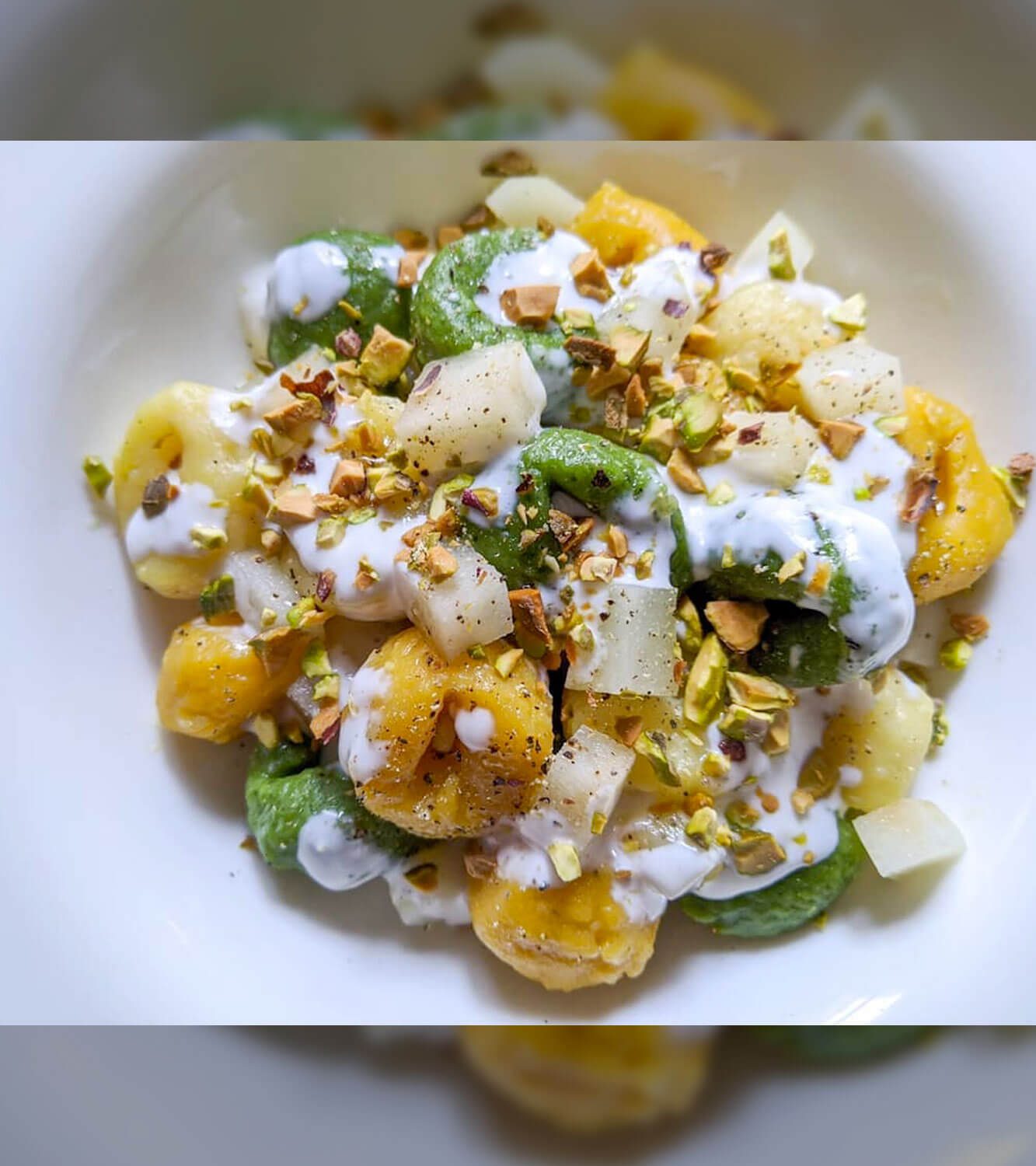 Tris di gnocchi con crema di crescenza, pera e pistacchi