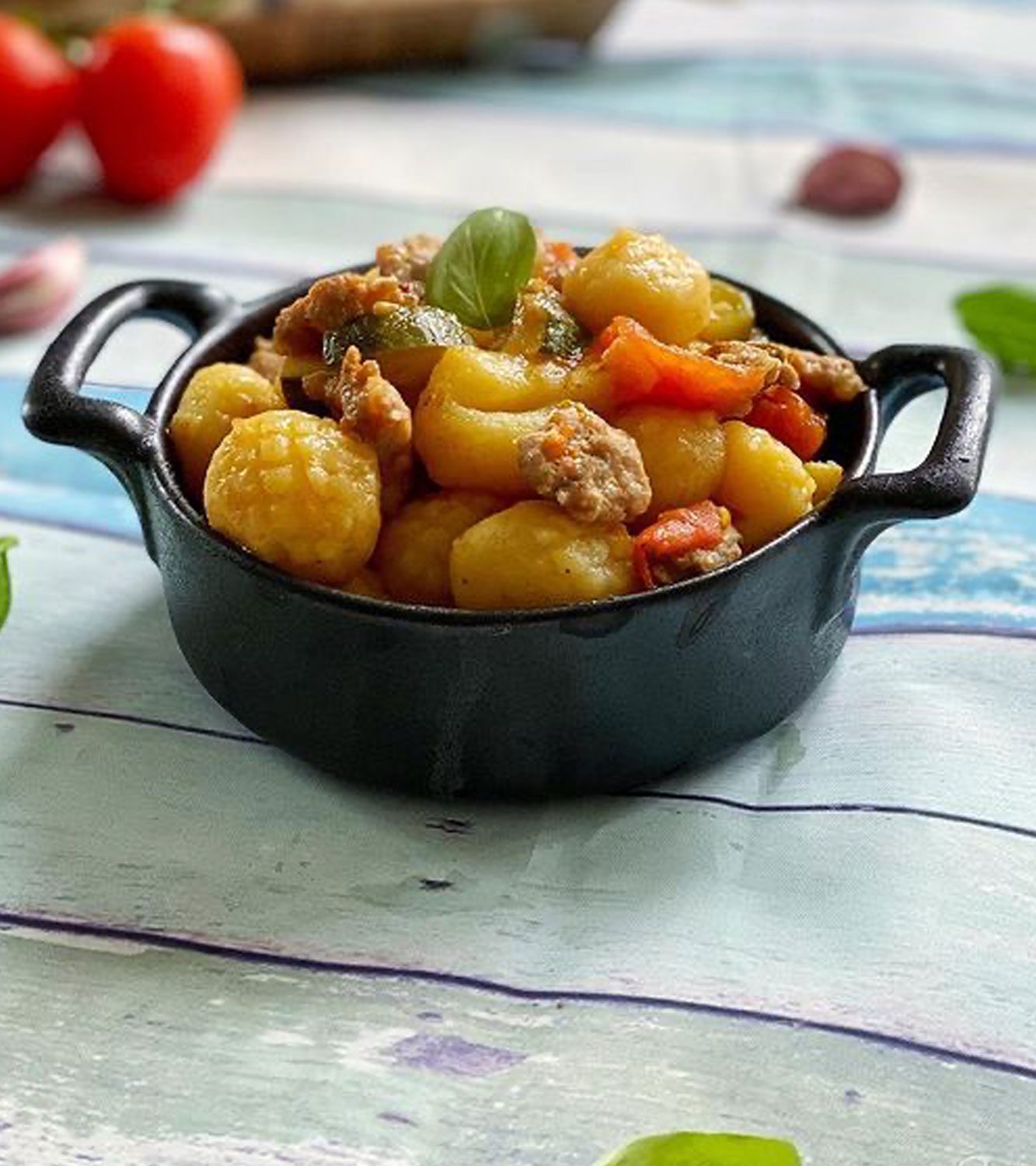 Gnocchi de papas primaverales con zapallo italiano, salchicha y tomates de paquino.