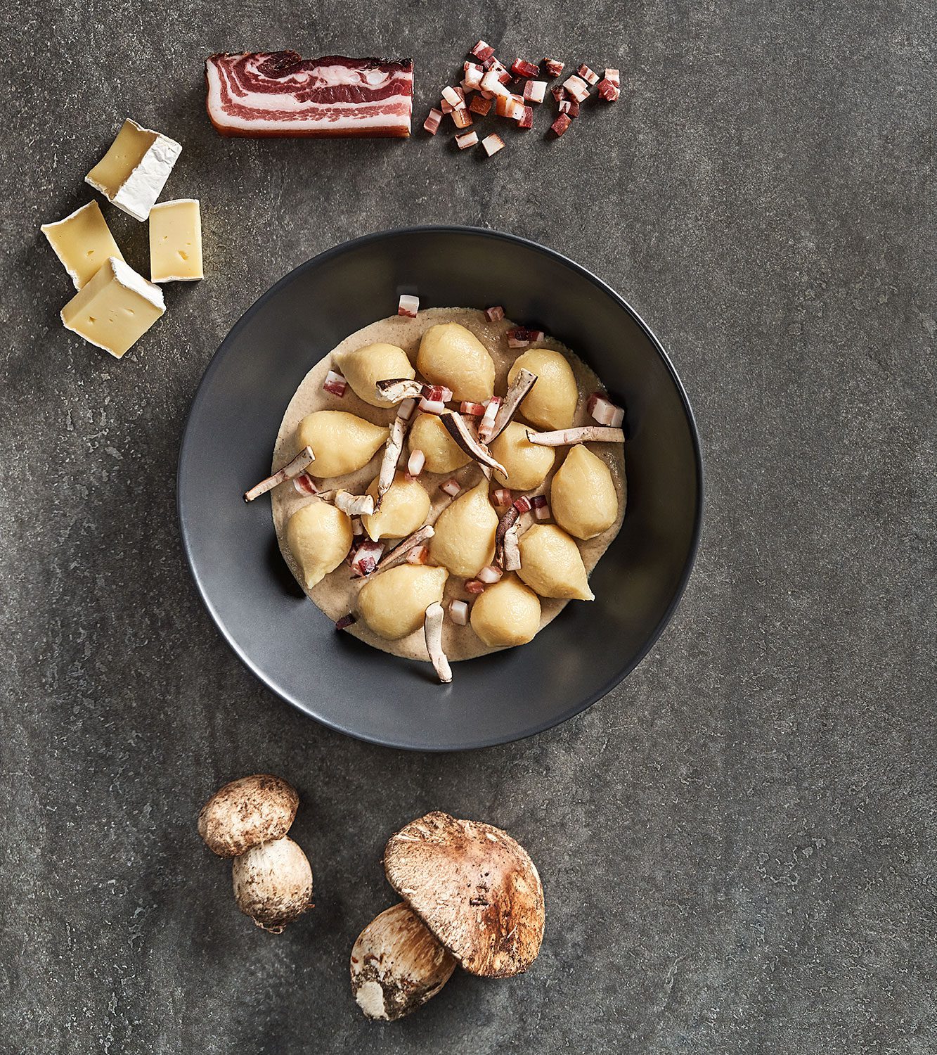 Potato gnocchi filled with speck and brie cheese with porcini mushrooms sauce